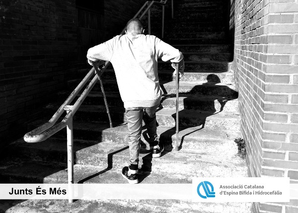 Peu de foto, logo de l’Associació Catalana d'Espina Bífida i Hidrocefàlia. Fotografia d’un noi d'esquenes pujant unes escales amb crosses.